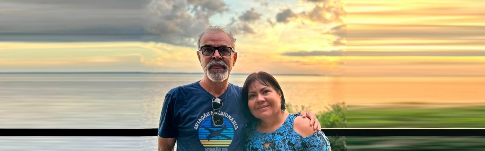 Airton e Vanda Silva à beira de um rio, ao entardecer