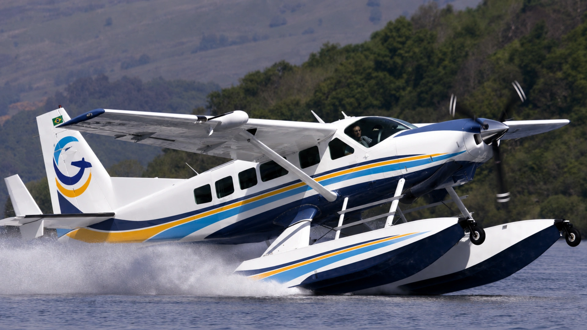 Aeronave anfíbia Cessna Caravan pousando na água, com as cores da Missão do Céu